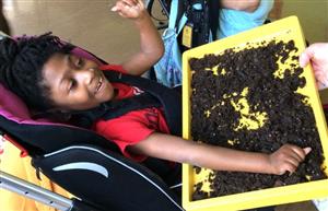 Student grabbing potting soil